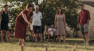 Partie de Mölkky sur une pelouse en été, quilles de bois au sol
